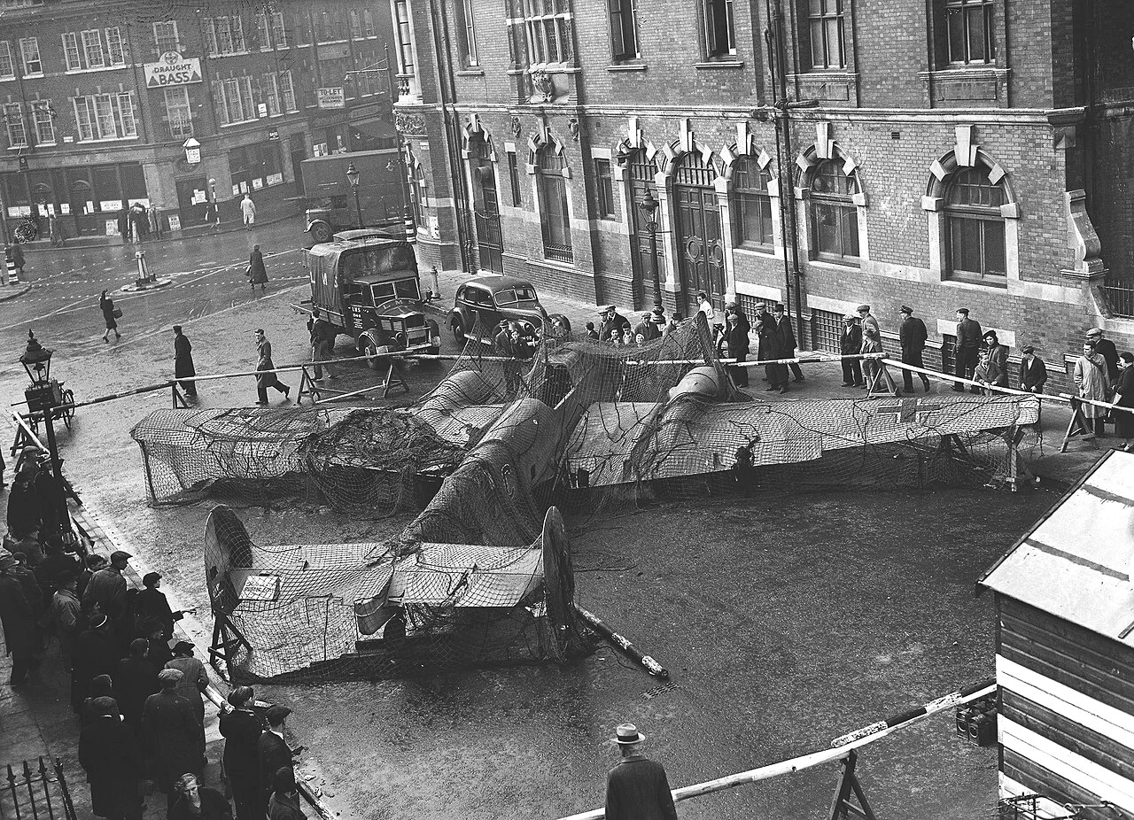 The wreck of a twin-engined German aircraft set up on display in front of a civic building