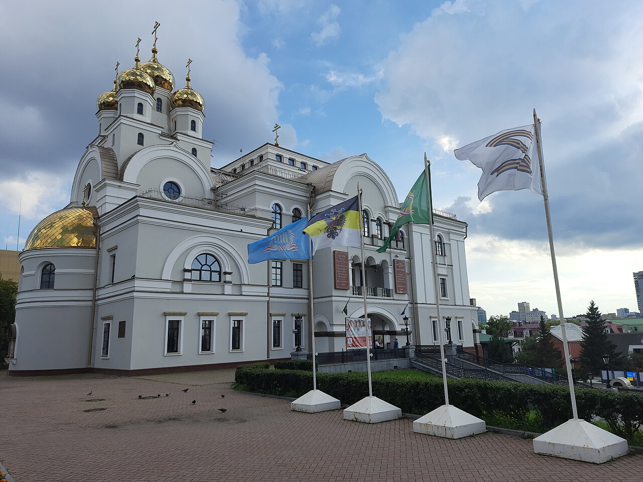 A large modern Russian Orthodox church with gold domes under a blue sky
